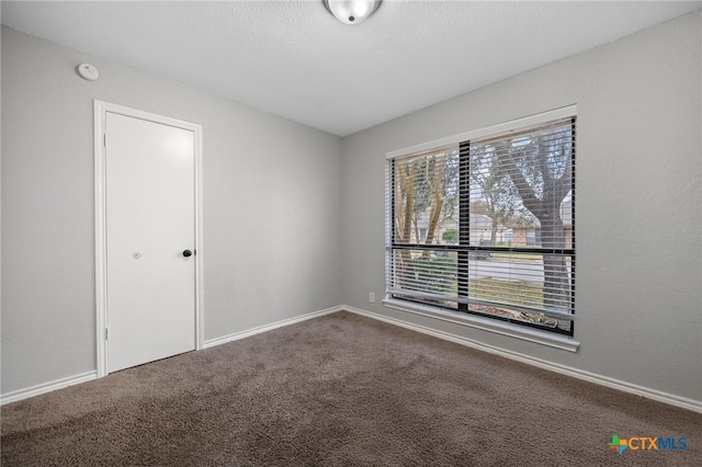 unfurnished room featuring carpet floors and a textured ceiling