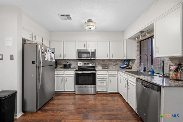 kitchen featuring stone counters, appliances with stainless steel finishes, and white cabinets