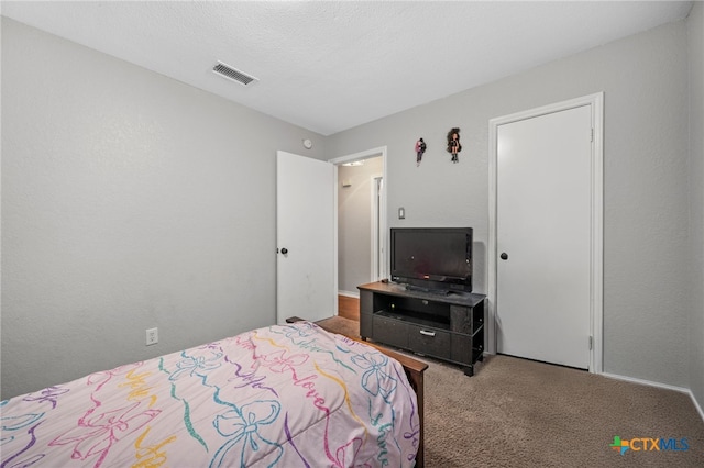 bedroom featuring a textured ceiling and carpet flooring