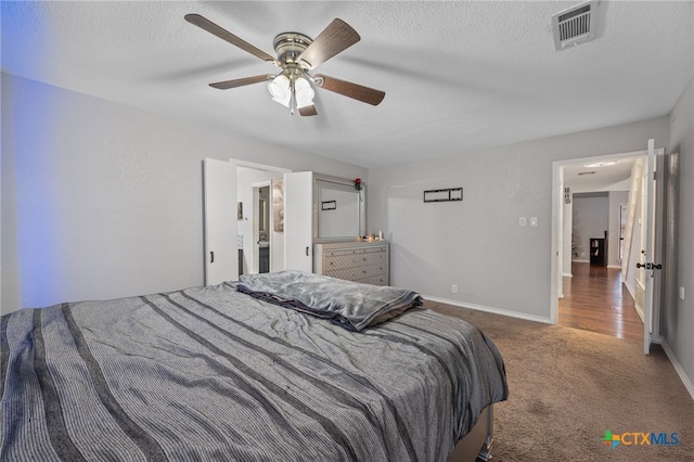 carpeted bedroom featuring ceiling fan and a textured ceiling