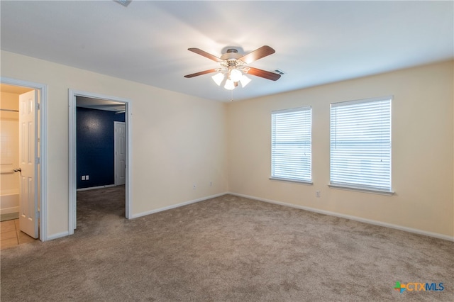 carpeted spare room with ceiling fan