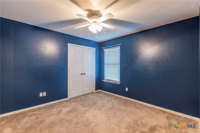 unfurnished room with ceiling fan and light colored carpet