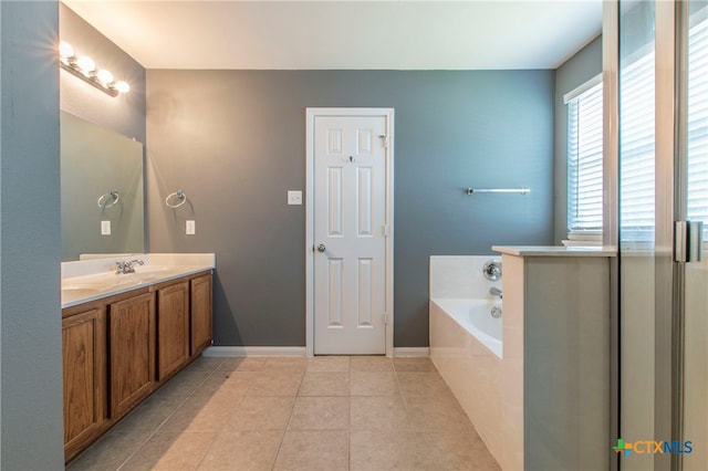 bathroom featuring a relaxing tiled tub, tile patterned floors, and vanity