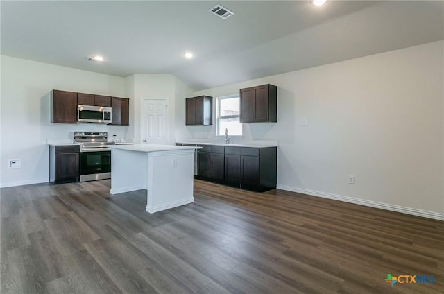 kitchen featuring dark brown cabinetry, appliances with stainless steel finishes, sink, and a kitchen island