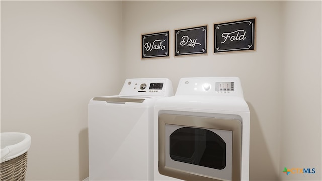 clothes washing area featuring separate washer and dryer