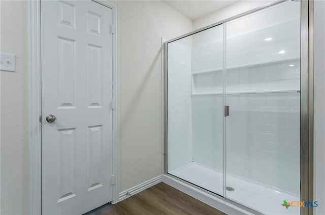 bathroom with hardwood / wood-style flooring and walk in shower