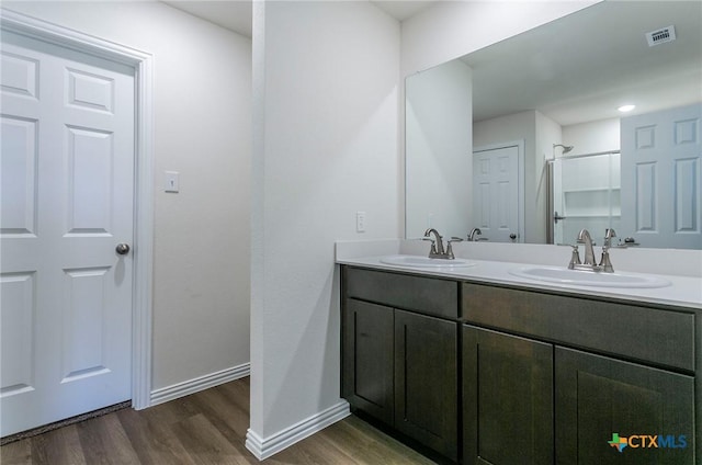 bathroom featuring walk in shower, vanity, and hardwood / wood-style floors