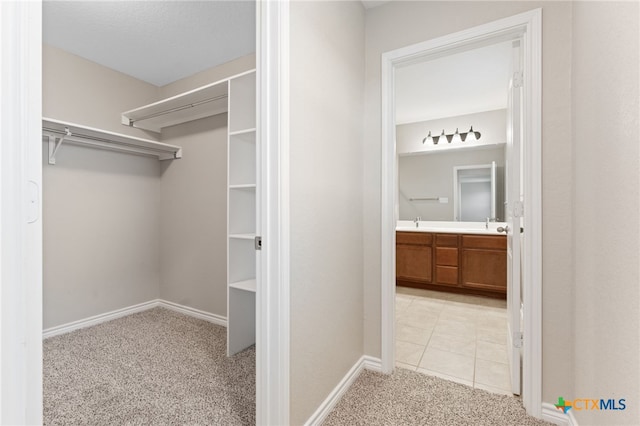 3907 Gentle Mdw, New Braunfels, TX 78130 - walk in closet with light colored carpet, a sink, and light tile patterned flooring