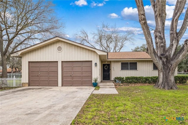 ranch-style home featuring a front yard, concrete driveway, fence, and an attached garage