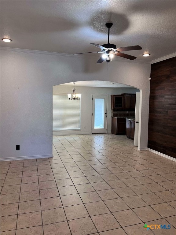 unfurnished living room with a textured ceiling, ceiling fan with notable chandelier, light tile patterned flooring, and crown molding