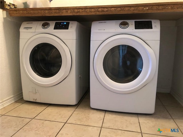 laundry area with light tile patterned floors and independent washer and dryer