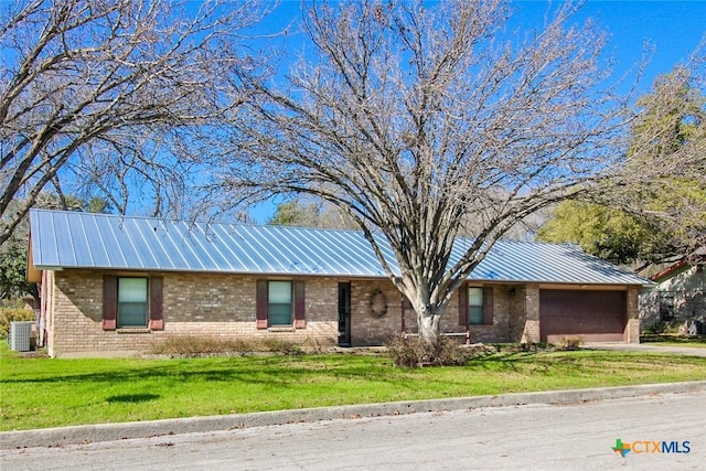 single story home featuring cooling unit, a garage, and a front lawn