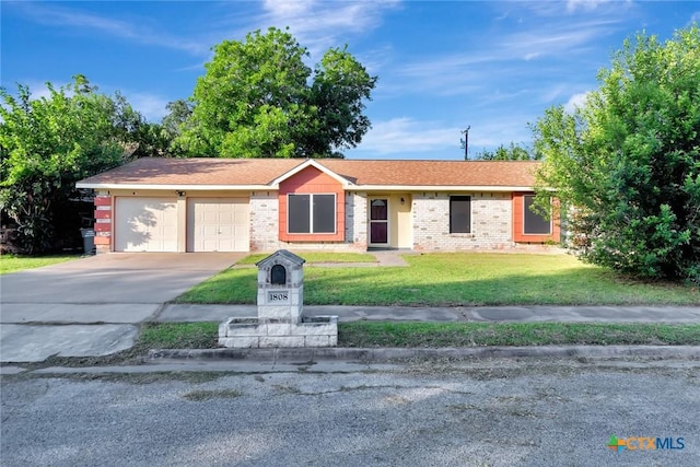 1808 Mission Dr, Victoria, TX 77901 - ranch-style home with an attached garage, driveway, a front lawn, and brick siding