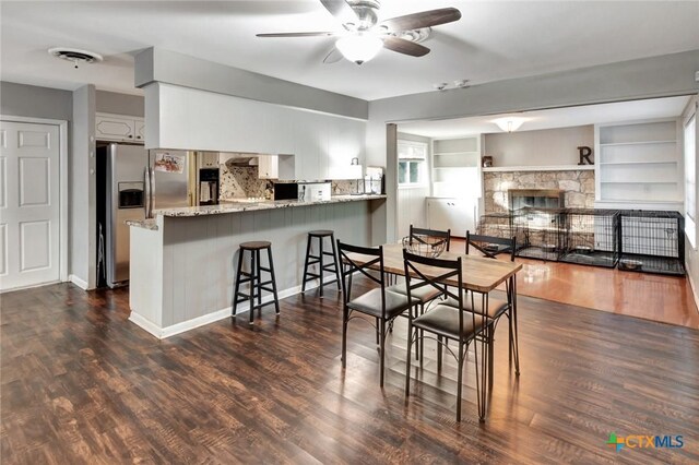 1808 Mission Dr, Victoria, TX 77901 - dining space featuring ceiling fan, a fireplace, and dark wood-style flooring