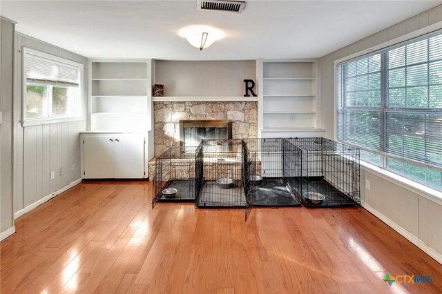 1808 Mission Dr, Victoria, TX 77901 - unfurnished living room with built in shelves, wood finished floors, baseboards, and a fireplace