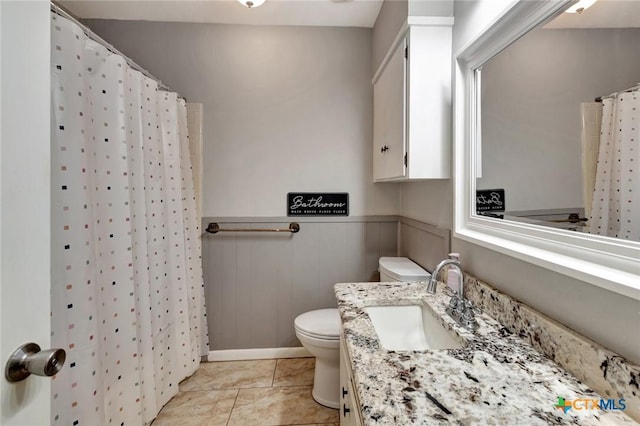 1808 Mission Dr, Victoria, TX 77901 - bathroom featuring toilet, vanity, a wainscoted wall, and a shower with curtain