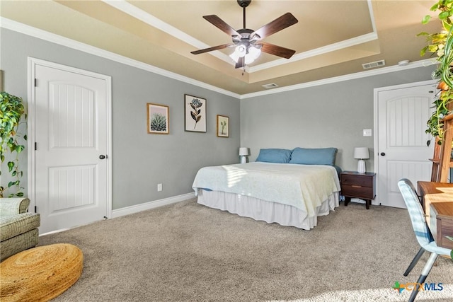 carpeted bedroom featuring ceiling fan, crown molding, and a tray ceiling