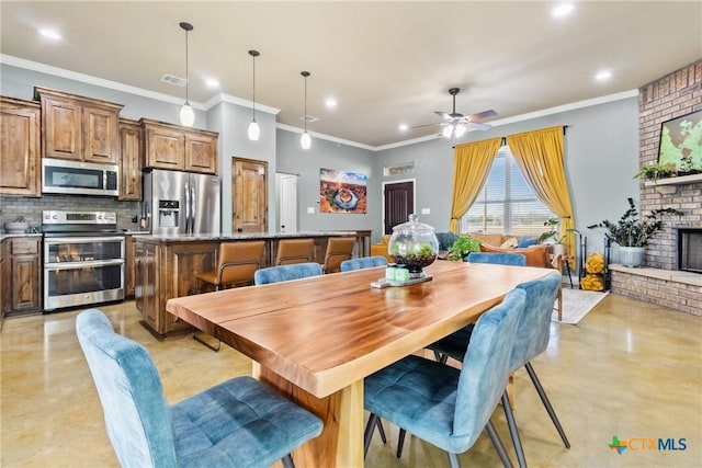 dining area with ceiling fan, ornamental molding, and a fireplace