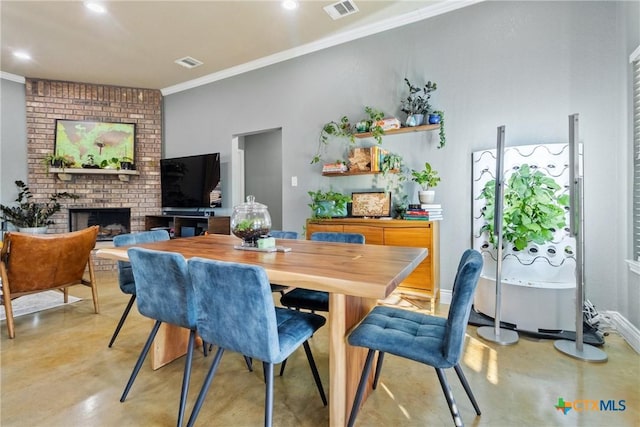 dining space with a brick fireplace and crown molding