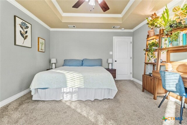 carpeted bedroom with a raised ceiling, ceiling fan, and crown molding