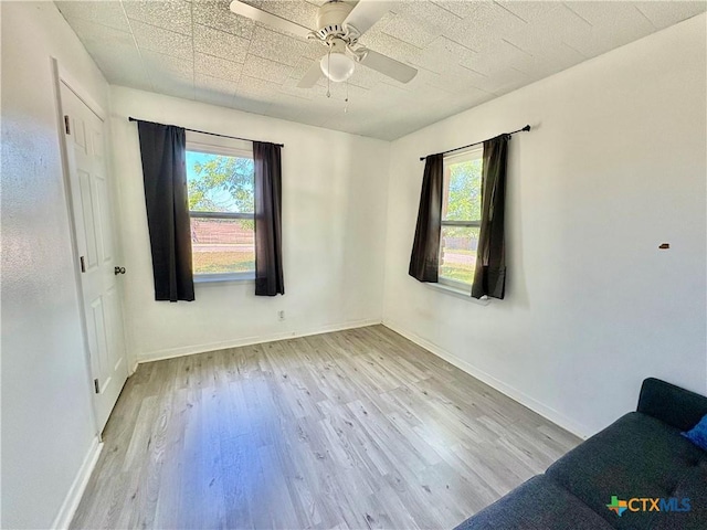 1003 Standifer St, Lampasas, TX 76550 - empty room with plenty of natural light, wood finished floors, ceiling fan, and baseboards