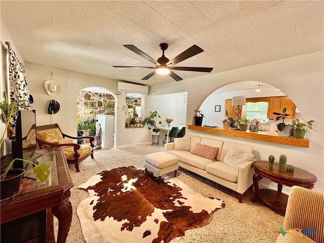 1003 Standifer St, Lampasas, TX 76550 - living area featuring carpet floors, arched walkways, a ceiling fan, and a wall unit AC