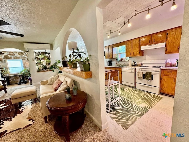 1003 Standifer St, Lampasas, TX 76550 - kitchen featuring white appliances, under cabinet range hood, brown cabinetry, and open floor plan