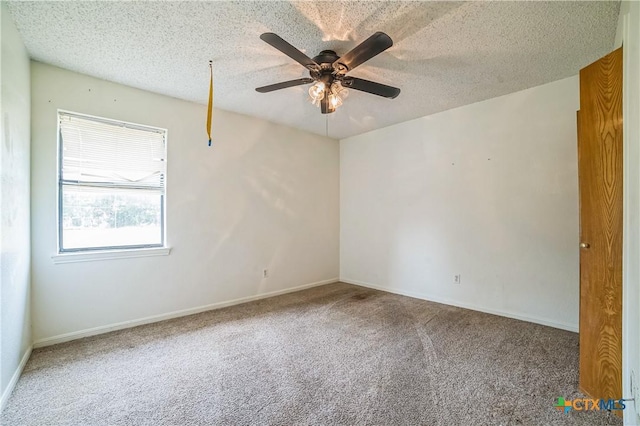 unfurnished room with carpet floors, a ceiling fan, a textured ceiling, and baseboards