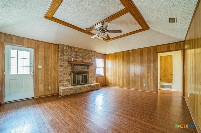 unfurnished living room with visible vents, a textured ceiling, and wood finished floors
