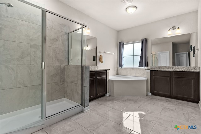 bathroom with vanity and shower with separate bathtub