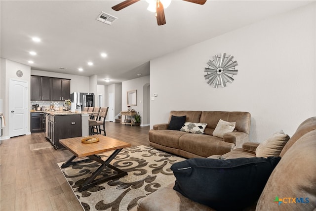 living room with dark hardwood / wood-style floors and ceiling fan