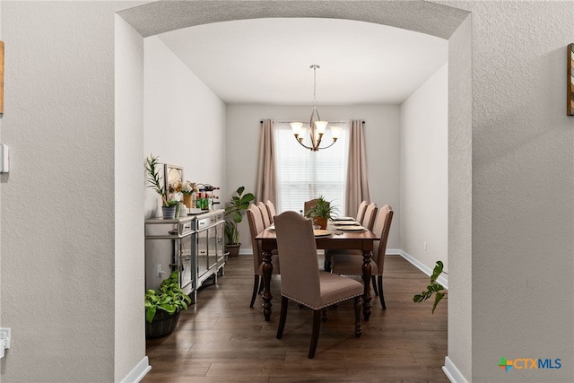 dining space featuring dark hardwood / wood-style floors and a chandelier