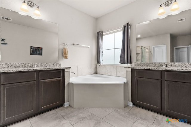 bathroom with vanity and shower with separate bathtub