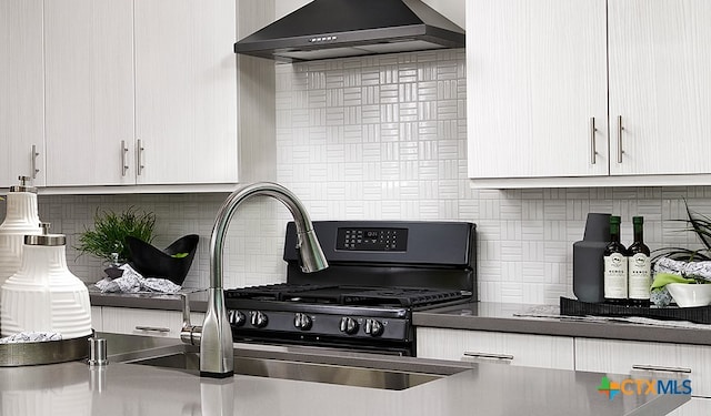 kitchen with backsplash, sink, and wall chimney exhaust hood