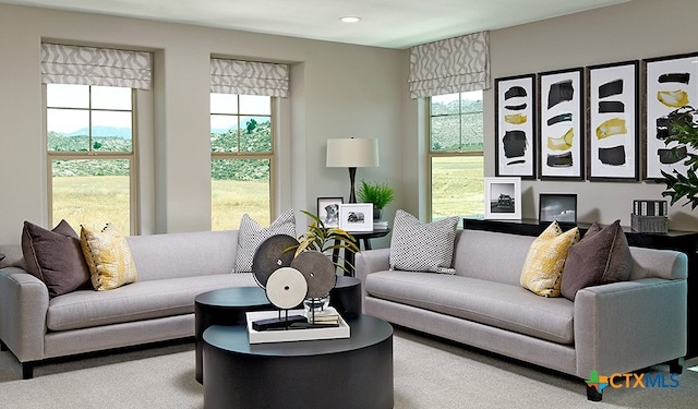 living room with a wealth of natural light and carpet flooring