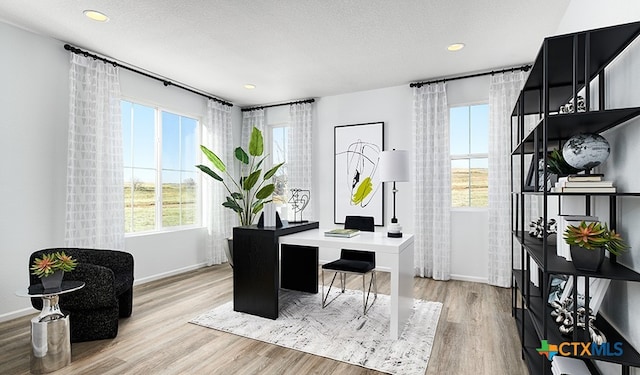 office space featuring a textured ceiling and light wood-type flooring