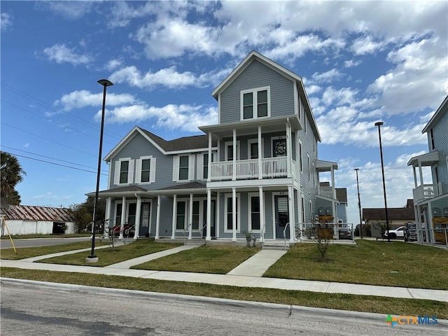 view of front of property featuring a balcony, covered porch, and a front yard