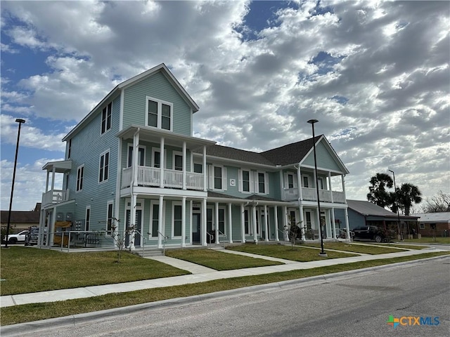 view of front facade featuring a front yard, covered porch, and a balcony