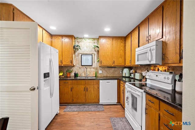 216 Ridge Dr, Victoria, TX 77904 - kitchen featuring white appliances, dark countertops, light wood-style floors, brown cabinets, and recessed lighting