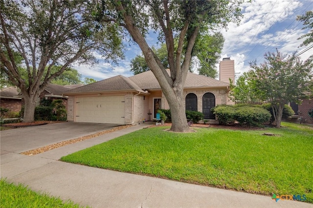 216 Ridge Dr, Victoria, TX 77904 - view of front of property with a chimney, brick siding, a garage, a front yard, and concrete driveway