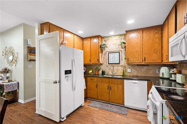 216 Ridge Dr, Victoria, TX 77904 - kitchen featuring white appliances, dark countertops, recessed lighting, light wood-style flooring, and decorative backsplash