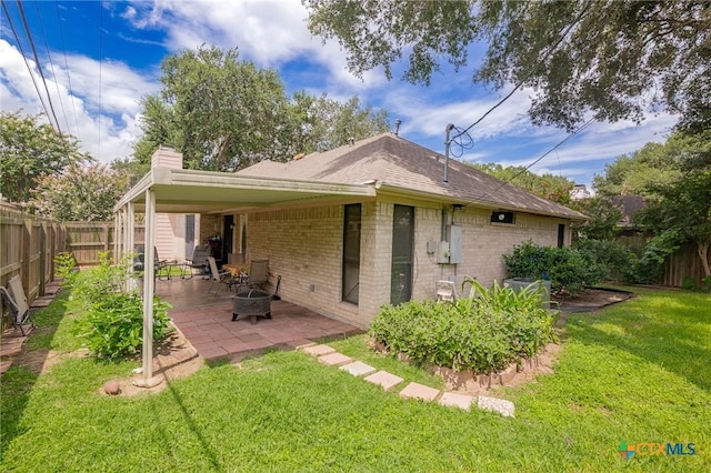 216 Ridge Dr, Victoria, TX 77904 - back of house with brick siding, a fenced backyard, a chimney, and a patio