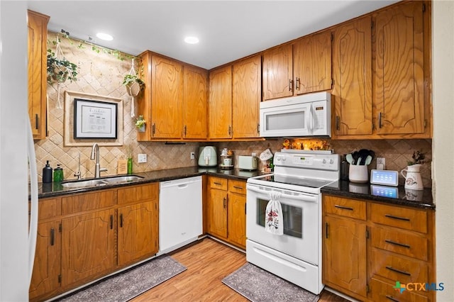 216 Ridge Dr, Victoria, TX 77904 - kitchen featuring white appliances, dark countertops, backsplash, light wood finished floors, and recessed lighting