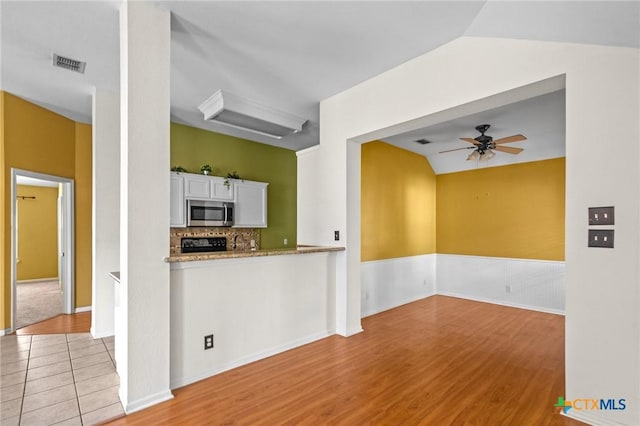 908 Pennsylvania Ave, Victoria, TX 77904 - kitchen featuring stainless steel microwave, a ceiling fan, white cabinets, decorative backsplash, and range