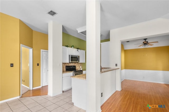 908 Pennsylvania Ave, Victoria, TX 77904 - kitchen with appliances with stainless steel finishes, a ceiling fan, white cabinetry, decorative backsplash, and light tile patterned floors