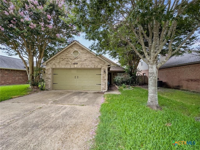 908 Pennsylvania Ave, Victoria, TX 77904 - ranch-style house with concrete driveway, a front yard, an attached garage, and brick siding