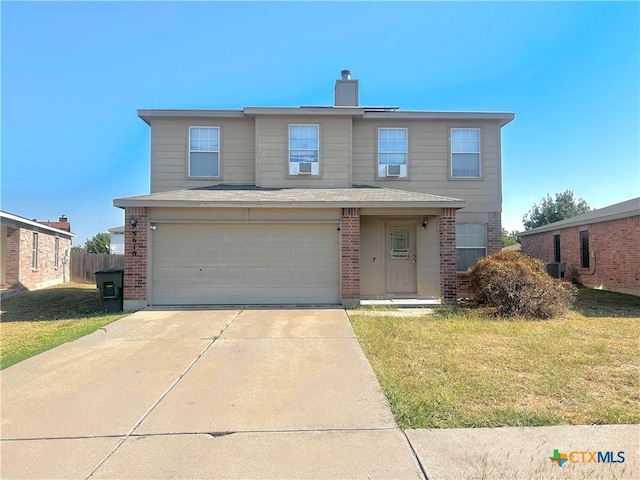 view of property featuring a garage and a front lawn