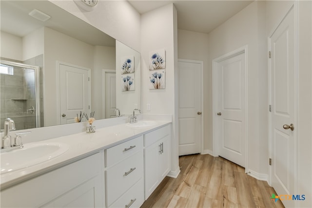 104 Hannah Trl, Georgetown, TX 78628 - bathroom with wood finished floors, a stall shower, and double vanity