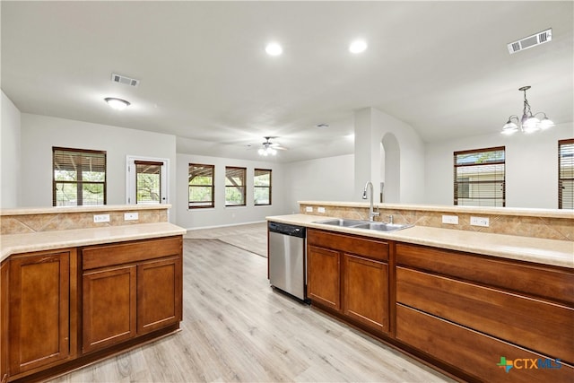 kitchen featuring light wood-type flooring, decorative light fixtures, sink, dishwasher, and ceiling fan with notable chandelier