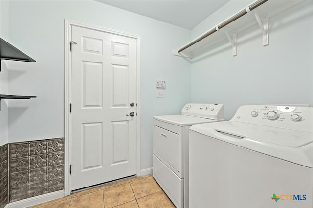 washroom featuring washing machine and clothes dryer and light tile patterned floors